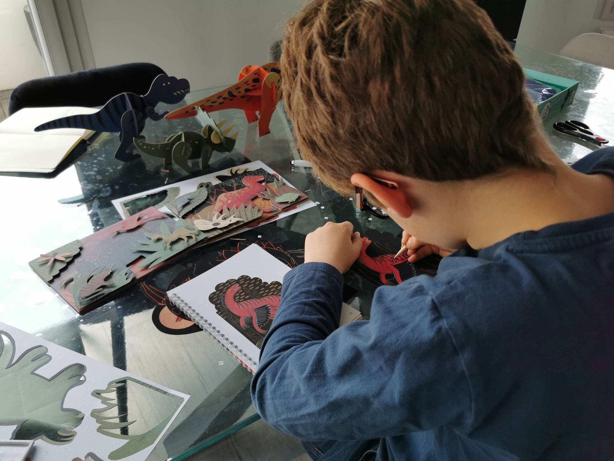 enfant autonome s'occupant avec le coffret d'activités dinosaure
