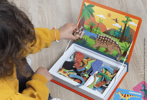 enfant tenant la boite du jeu magnétique dinosaure ouverte