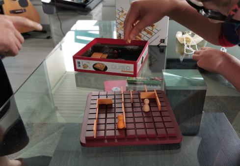 enfant piochant une pièce du jeu de stratégie quoridor